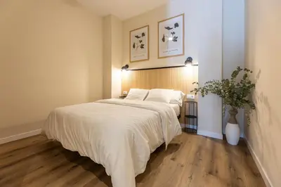 a bedroom with a large bed with white sheets at Pivote Flats - Marina A in Valencia