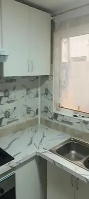 a white kitchen with a sink and a window at Juan in Carlet