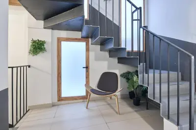 a room with a chair and a staircase at Apartamento elegante en Plaza del Carmen F2 in Valencia