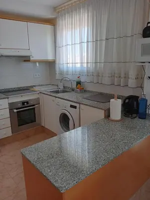 a kitchen with a sink and a washing machine at CANETSOL in Canet de Berenguer