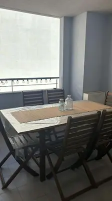 a dining room table with two chairs and a window at Acogedor apartamento en la playa con WIFI y AACC in Moncófar