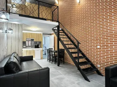 a living room with a staircase and a brick wall at Oriola 35 in Valencia