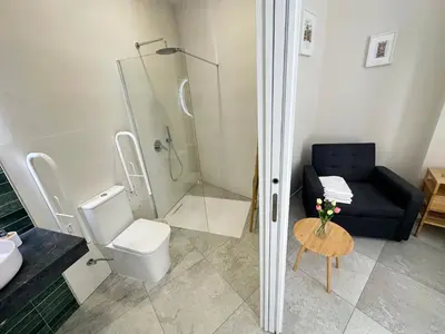 a bathroom with a shower and a toilet and a couch at Calma Lofts in Valencia