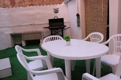 a white table and chairs in a room with a piano at La Casa del Castell in Onda