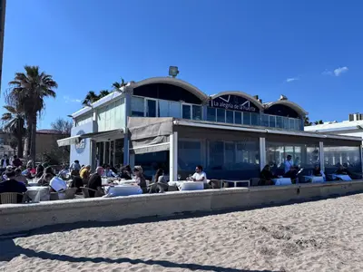 people sitting at tables on the beach near a building at Apartamento en Valencia in Valencia