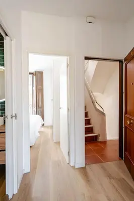 a white room with a hallway with a staircase and a door at Espectacular y luminoso apartamento en el centro in Valencia
