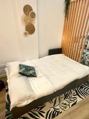 a bed in a bedroom with a fan on the wall at Loft Céntrico - The Essence by ValeciaGOapartments in Valencia
