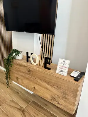 a flat screen tv sitting on top of a wooden dresser at Loft Céntrico - The Essence by ValeciaGOapartments in Valencia