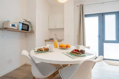 a white kitchen with a white table with fruit on it at Mediterraneum Suite F in Valencia