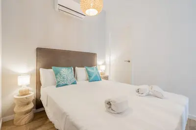 a bedroom with a large white bed with blue pillows at Mediterraneum Suite F in Valencia