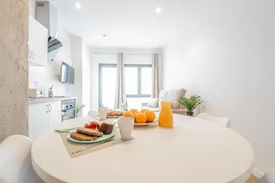 a white kitchen with a table with a plate of fruit at Mediterraneum Suite D in Valencia