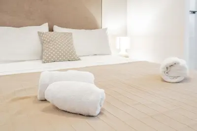 a white bedroom with a bed with towels on the floor at Mediterraneum Suite D in Valencia