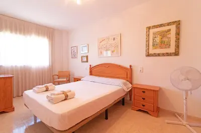 a bedroom with a bed and a fan at Global Vacacional, Apartamento con terraza de 70m y piscina en Canet de Berenguer in Canet de Berenguer