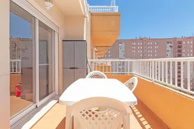 a white table and chairs on a balcony at Global Vacacional, Apartamento con terraza de 70m y piscina en Canet de Berenguer in Canet de Berenguer