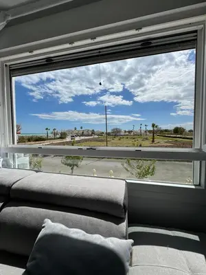 a living room with a large window looking out at the desert at La Costera in Barrio-Mar