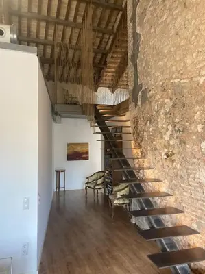 a spiral staircase in a room with a stone wall at molino rehabilitado con gran terraza y piscina in Paterna