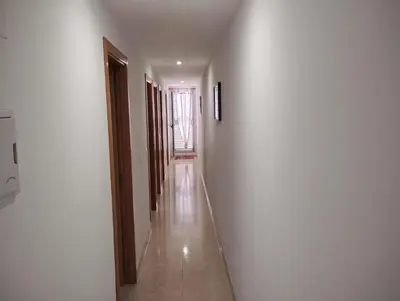 a hallway with white walls and a long aisle at Apartamento en la playa in Moncófar