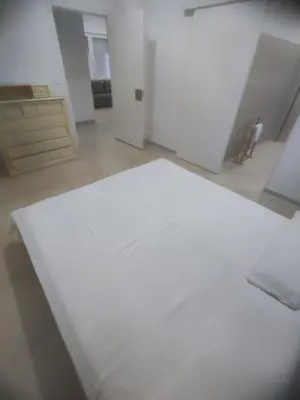 a white bedroom with a bed and a dresser at Valencia Beach PINK in Valencia