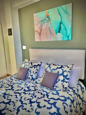a bed with blue and white sheets and pillows at Elegant Rooftop by F2 Rental Home in Valencia