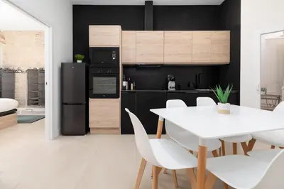 a kitchen with a white table and white chairs at Apartamento Ruzafa 1 habitacion y 2 sofas cama in Valencia