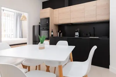 a kitchen with a white table and white chairs at Apartamento Ruzafa 1 habitacion y 2 sofas cama in Valencia