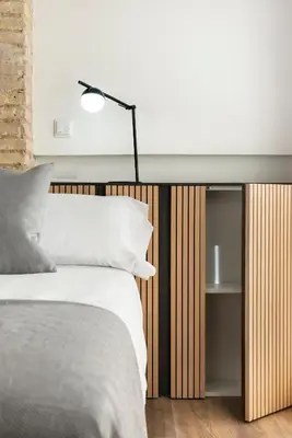 a bedroom with a bed and a table with a lamp at Apartamentos Maestro Sosa in Valencia