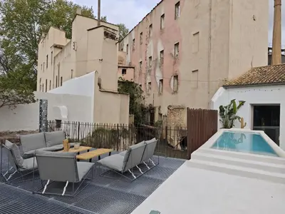 a patio with a table and chairs and a pool at Ático loft en molino antiguo in Paterna