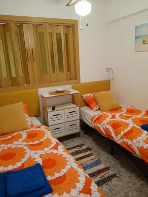 a bedroom with two beds and a dresser in it at TIGA muy cerca de la plaza de San Antonio in Cullera