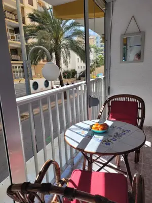 a table and chairs on a balcony with a view of a street at TIGA muy cerca de la plaza de San Antonio in Cullera