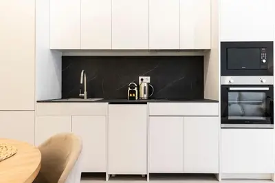 a white kitchen with a sink and a microwave at Favara Suites A by Concept Flats in Valencia