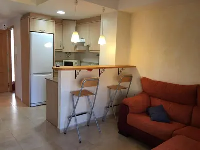 a kitchen with a bar and a couch in a room at BRISA de MAR in Moncófar
