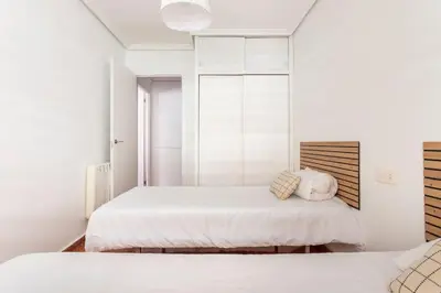 two beds in a bedroom with white walls at Villamar ,ACC, playa wifi y garaje in Cullera