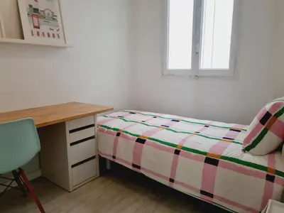 a bedroom with a bed and a desk and a window at PATRAIX FLAT in Valencia