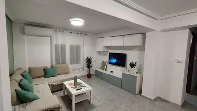 a living room with a couch and a tv at Sea view apartment, first line on the beach, Remote work in Canet de Berenguer