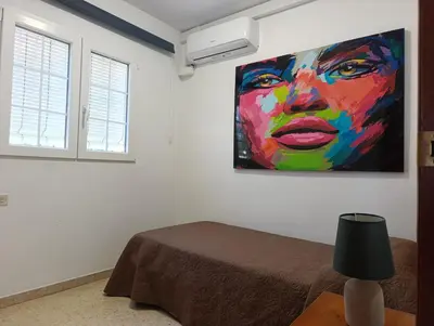 a room with a painting of a woman on the wall at Apartamento 1 linea mar terraza Port Saplaya in Port Saplaya