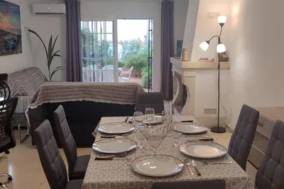 a dining room with a table with plates and wine glasses at Apartamento 1 linea mar terraza Port Saplaya in Port Saplaya