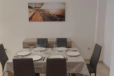 a table with plates and wine glasses on it at Apartamento 1 linea mar terraza Port Saplaya in Port Saplaya