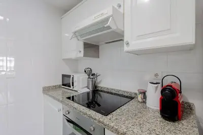 a kitchen with white cabinets and a counter top at Apartamento playa Patacona con parking in Valencia