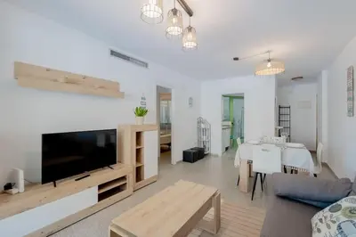 a living room with a large television and a table at Apartamento playa Patacona con parking in Valencia