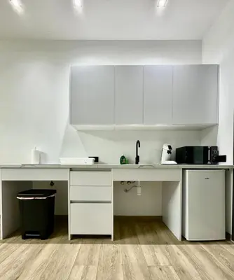 a kitchen with white cabinets and a counter top at Valencia Veneta Calda in Valencia