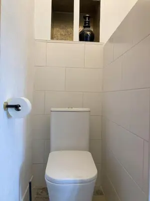 a white bathroom with a toilet and a toilet paper dispenser at Villa Torre, Valencia Spanje in Macastre