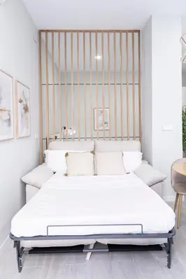 a bedroom with a white bed with a metal headboard at Favara Suites B by Concept Flats in Valencia