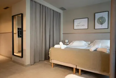 a bedroom with a bed with white pillows and a mirror at Apartamentos 87 Llaves in Valencia