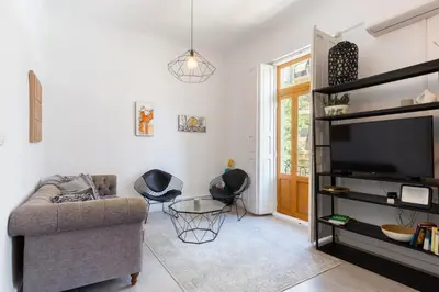 a living room with a couch and a flat screen tv at at Maestro Gozalbo, Ruzafa in Valencia