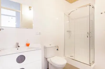 a white bathroom with a toilet and a shower at at Maestro Gozalbo, Ruzafa in Valencia
