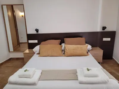 a bedroom with a large bed with towels on it at Living Valencia Apartments - Merced in Valencia