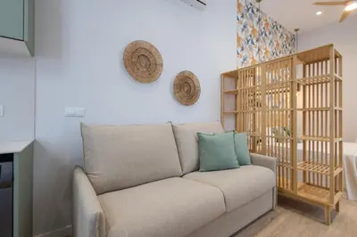 a living room with a couch and a shelf at FLORIT FLATS - Trafalgar Arts & Port Suites in Valencia