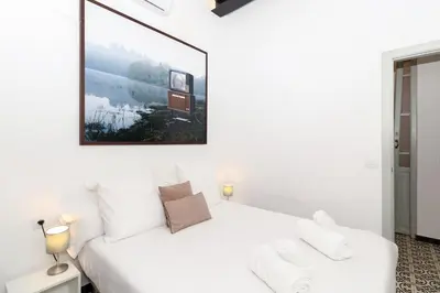 a white bedroom with a white bed and a picture on the wall at GuestReady - A perfect stay in Ciutat Vella in Valencia