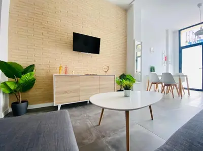 a living room with a tv on a brick wall at Beach Flat for Family & Groups in Valencia