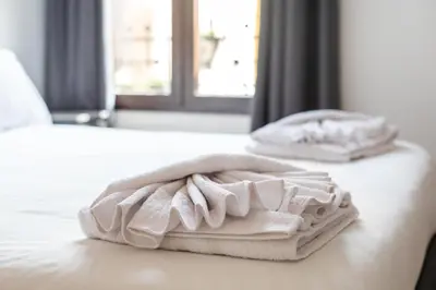 two white towels sitting on top of a bed at Mestalla Apartment Ideal for Mid-Term Stays in Valencia